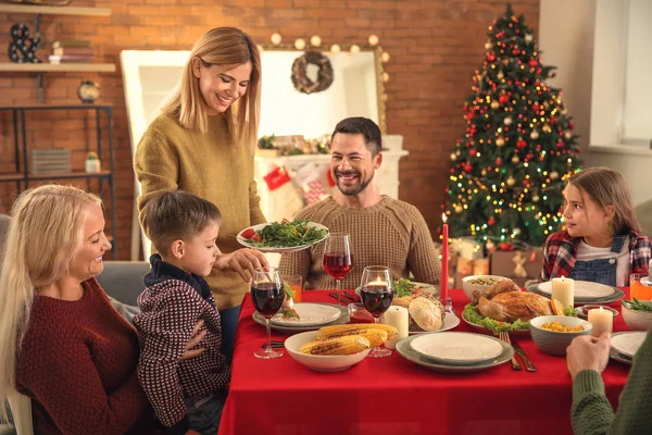 Glad familj som äter julmiddag hemma — Stockfoto