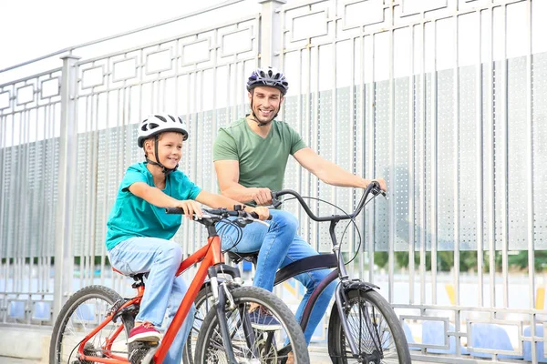 Щасливий батько і син катаються на велосипедах на відкритому повітрі — стокове фото