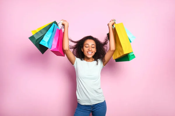 Portré boldog afro-amerikai nő bevásárló táskák színes háttér — Stock Fotó