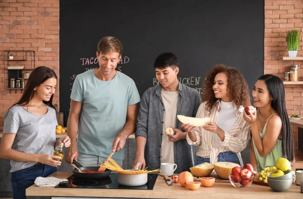 Glückliche Freunde kochen gemeinsam in der Küche — Stockfoto