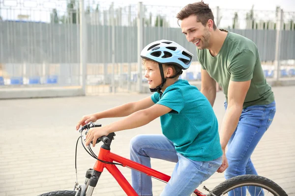 Padre enseñando a su hijo a andar en bicicleta al aire libre —  Fotos de Stock