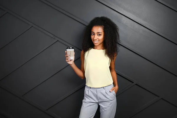 Porträt einer schönen afrikanisch-amerikanischen Frau mit einer Tasse Kaffee auf dunklem Hintergrund — Stockfoto