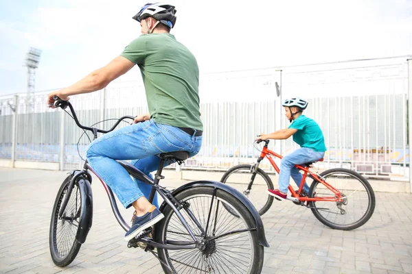 Feliz padre e hijo montando bicicletas al aire libre —  Fotos de Stock