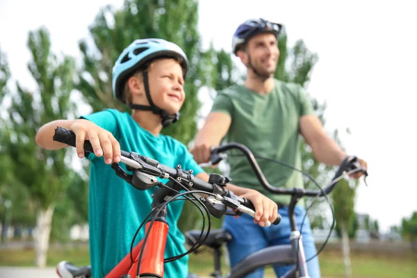 Happy father and son riding bicycles outdoors — Stock Photo, Image