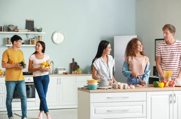 Amigos felizes cozinhar juntos na cozinha — Fotografia de Stock