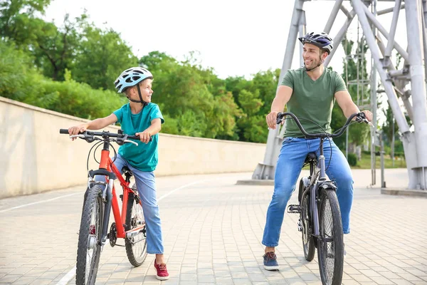 Feliz padre e hijo montando bicicletas al aire libre —  Fotos de Stock