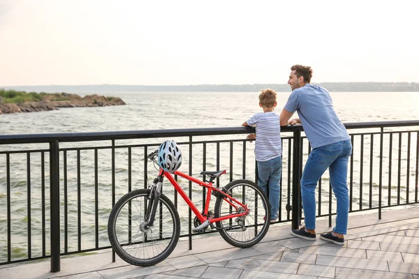 Padre y su hijito con bicicleta cerca del río — Foto de Stock