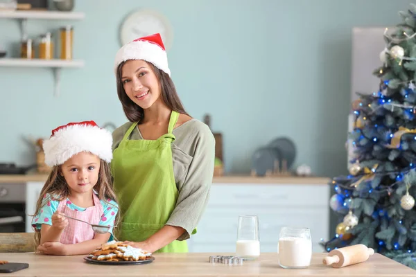 Kvinna och hennes lilla dotter förbereder julkakor hemma — Stockfoto