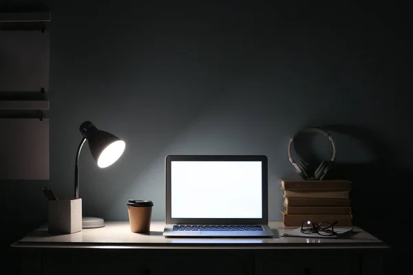 Modern workplace with laptop in evening — Stock Photo, Image