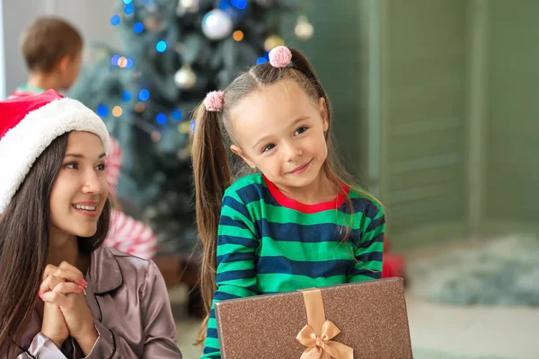 Mulher e sua filhinha com presente de Natal em casa — Fotografia de Stock