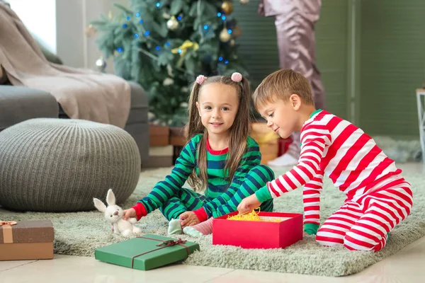 Lindos niños pequeños con regalos de Navidad en casa — Foto de Stock