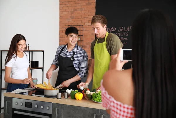 Aziatische vrouw het nemen van foto van haar vrienden koken in de keuken — Stockfoto