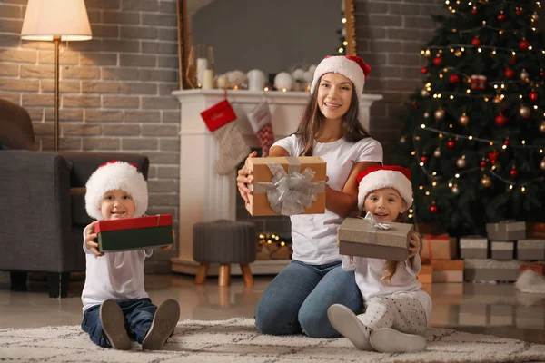 Mulher e seus filhos com presentes em casa na véspera de Natal — Fotografia de Stock