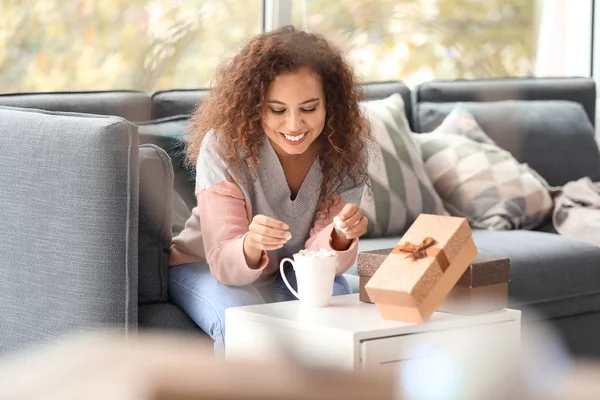 Young African-American woman drinking hot chocolate at home on Christmas eve — Stock Photo, Image