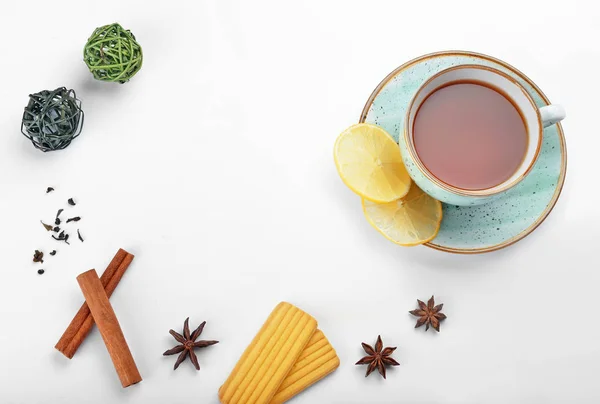 Cup of tasty tea with spices and cookies on white background — Stock Photo, Image