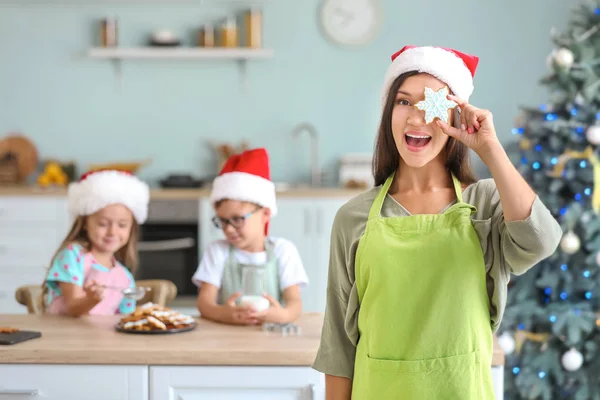 Woman and her little children preparing Christmas cookies at home — Stock Photo, Image