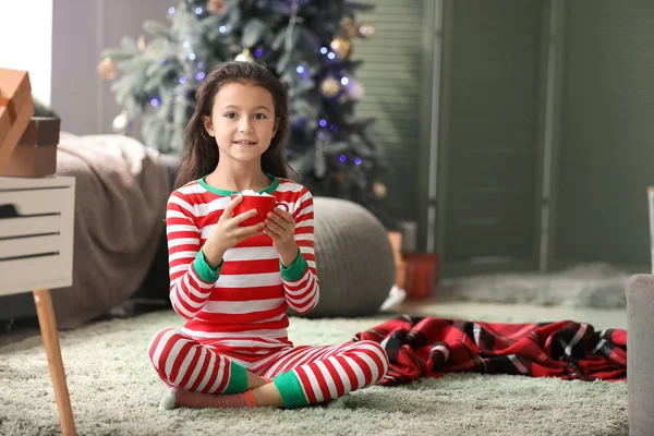 クリスマスイブに自宅でホットチョコレートを飲む小さな女の子 — ストック写真