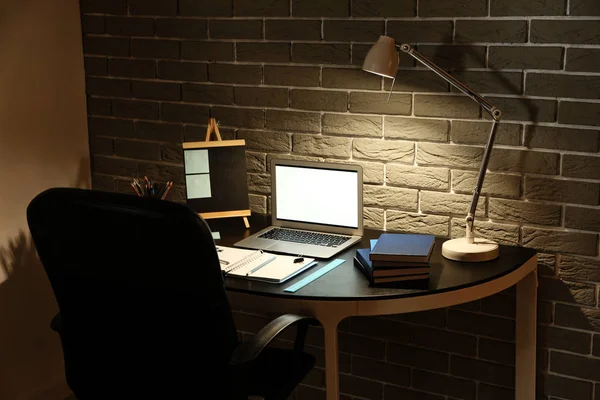 Blick auf bequemen Arbeitsplatz mit Laptop am Abend — Stockfoto