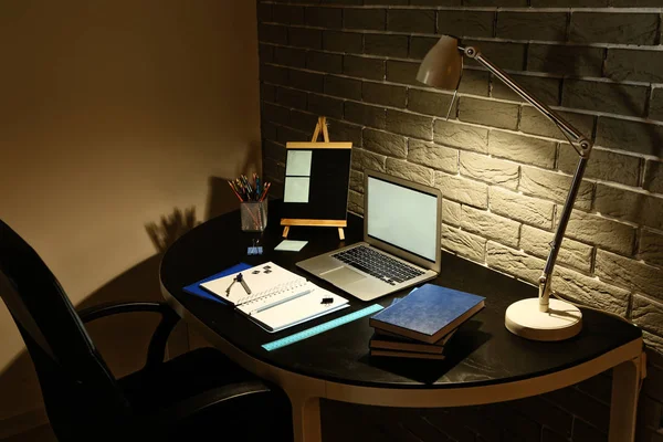 View of comfortable workplace with laptop in evening — Stock Photo, Image