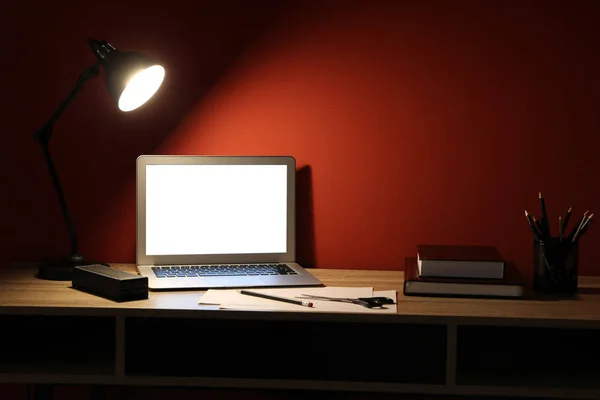 Utsikt över bekväm arbetsplats med laptop på kvällen — Stockfoto