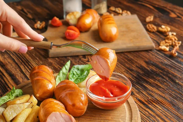 Woman eating tasty grilled sausage with sauce, closeup — Stock Photo, Image