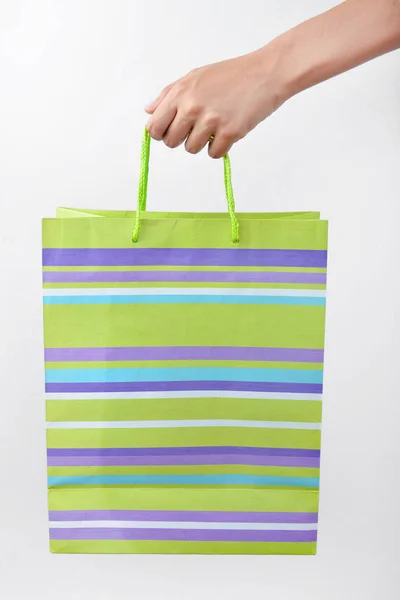 Женская рука с сумкой для покупок на белом фоне — стоковое фото