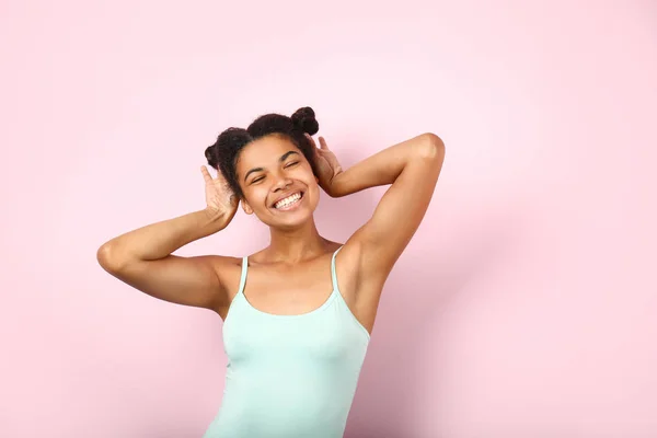 Šťastná mladá afroameričanka na barevném pozadí — Stock fotografie