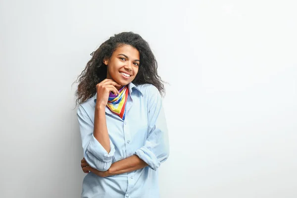 Bella giovane donna afro-americana su sfondo chiaro — Foto Stock