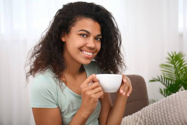 Güzel genç Afrikalı-Amerikalı kadın evde kahve içme