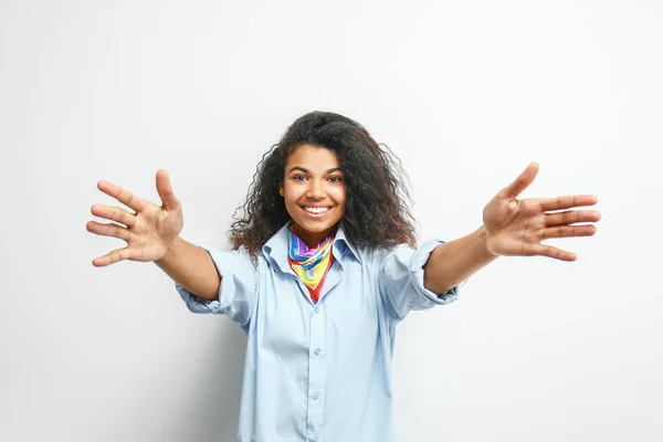 Glückliche junge afrikanisch-amerikanische Frau auf hellem Hintergrund — Stockfoto