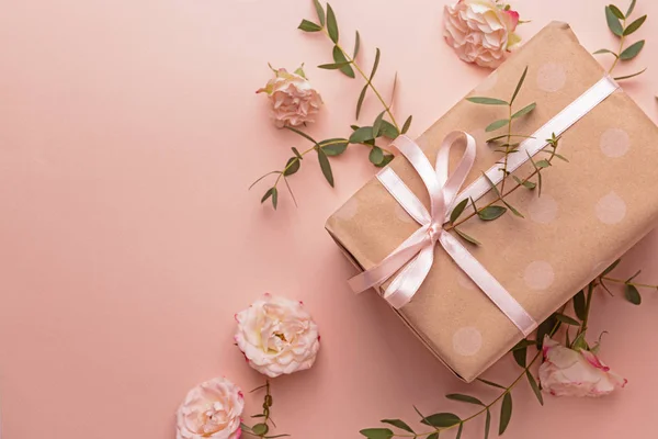 Gift box and beautiful flowers on color background — Stock Photo, Image