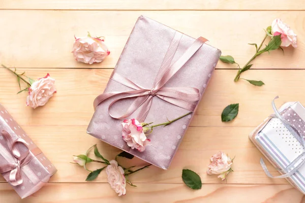 Κουτιά δώρων και όμορφα λουλούδια σε ξύλινο φόντο — Φωτογραφία Αρχείου