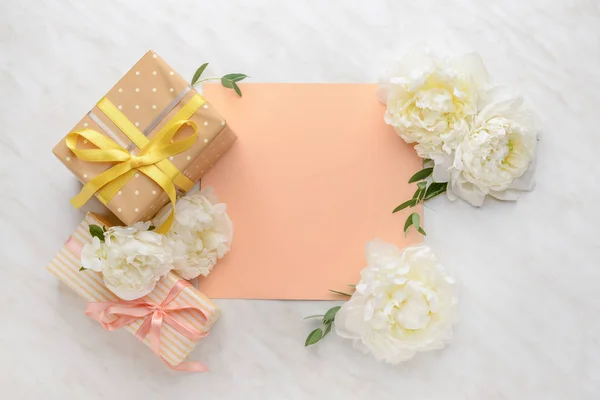 Presentaskar, blank kort och vackra blommor på ljus bakgrund — Stockfoto