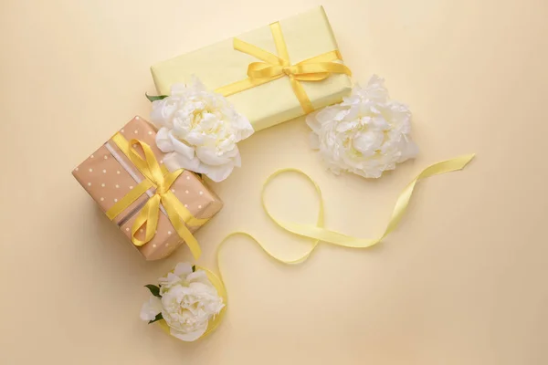 Dárkové krabice a krásné květiny na barevném pozadí — Stock fotografie