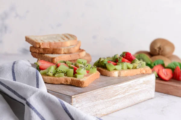 나무 판에 키위와 딸기를 곁들인 맛있는 샌드위치 — 스톡 사진