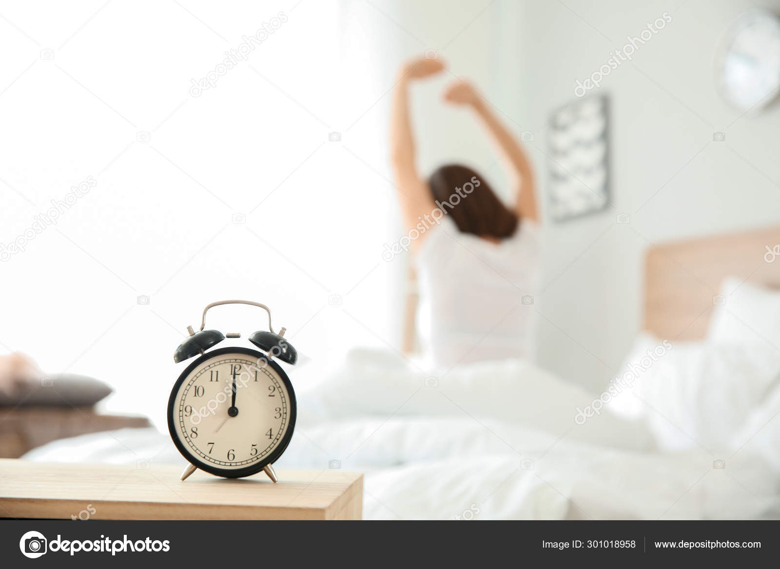 Reloj despertador en la mesa en el dormitorio de mujer joven