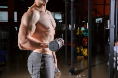 Spor salonunda Dambıl ile sportif genç adam