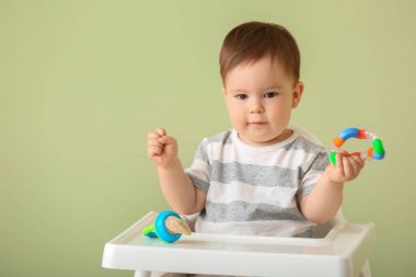 Renkli arka plan karşı yüksek sandalyede oturan Nibbler ile sevimli küçük çocuk