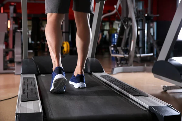 Sportlicher junger Mann trainiert auf Laufband im Fitnessstudio — Stockfoto