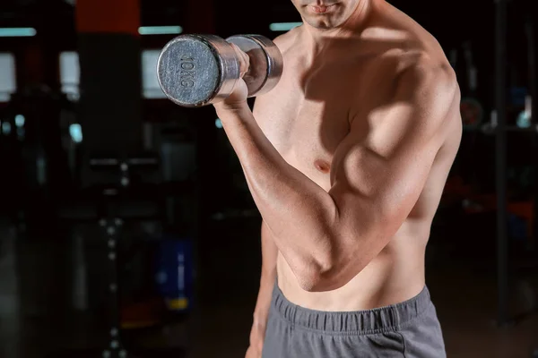 Joven deportivo con mancuernas en el gimnasio — Foto de Stock