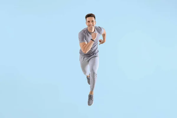 Running young man on color background — Stock Photo, Image