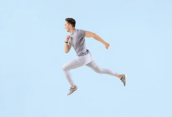 Bieganie młody człowiek na tle kolorów — Zdjęcie stockowe