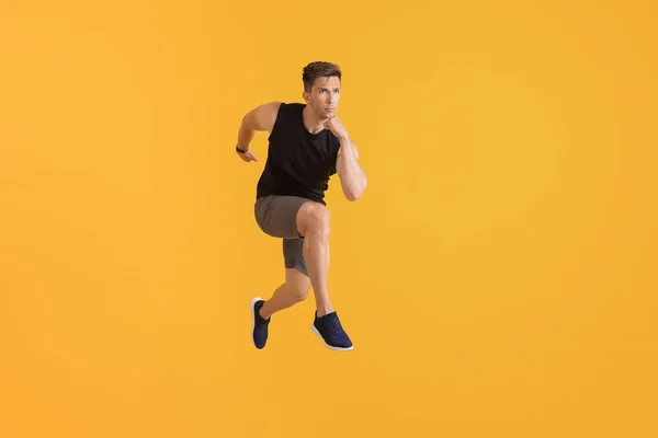 Laufender junger Mann auf farbigem Hintergrund — Stockfoto