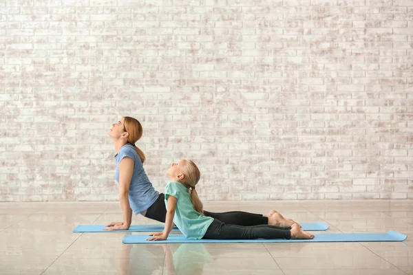 Matka z małą dziewczynką robi jogi w pomieszczeniu — Zdjęcie stockowe