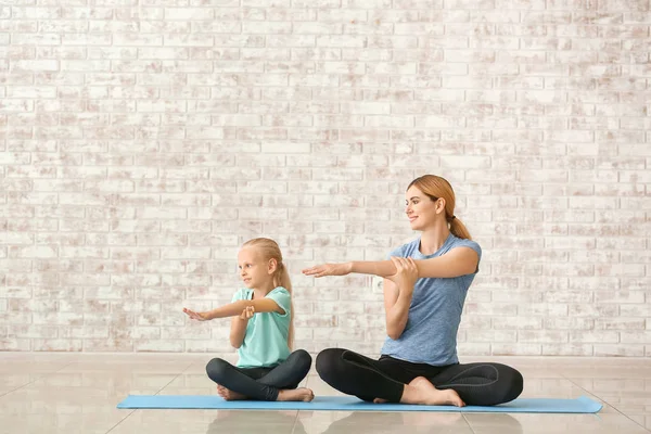 Matka z małą dziewczynką robi jogi w pomieszczeniu — Zdjęcie stockowe