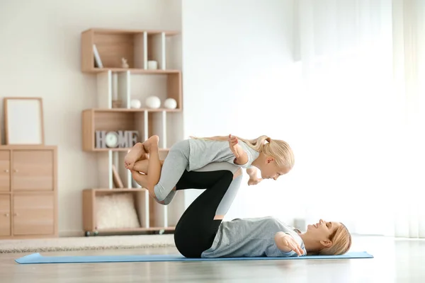 Mãe com a menina fazendo ioga em casa — Fotografia de Stock