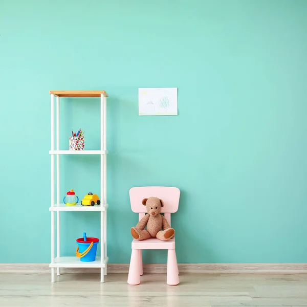Stylish furniture with toys near color wall in children's room — Stock Photo, Image