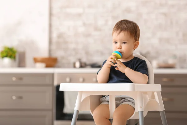 Lindo niño pequeño con mordisquito en la cocina en casa — Foto de Stock