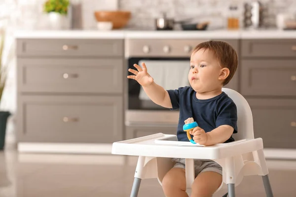 Cute little boy with nibbler in kitchen at home — Stock Photo, Image