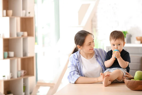 Mother and her little son with nibbler in kitchen at home — Stock Photo, Image